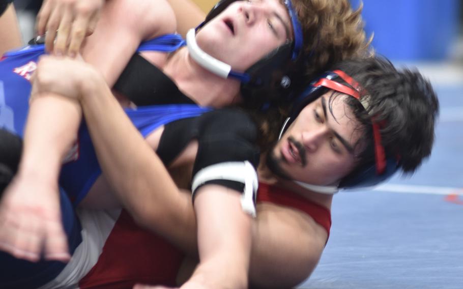 Lakenheath’s Lucius Bowman tries to get a grip on Ramstein’s Lucas Hollenbeck in the 165-pound finals at the DODEA-Europe wrestling sectional tournament at Ramstein High School, Germany, on Saturday, Feb. 3, 2024.