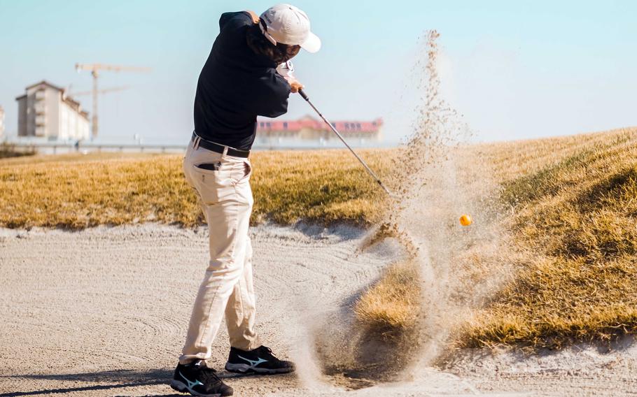 Humphreys' Brandon Borelli blasts out of a bunker en route to a 7 and 6 win over Osan's Joseph Koo.