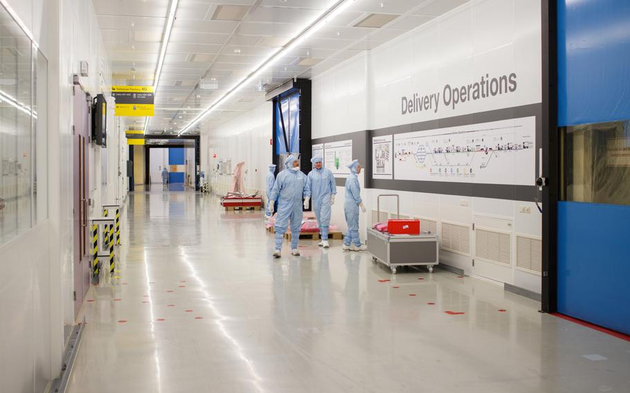 A 2014 photos shows employees standing in a corridor at the ASML Holding factory in Veldhoven, Netherlands. 