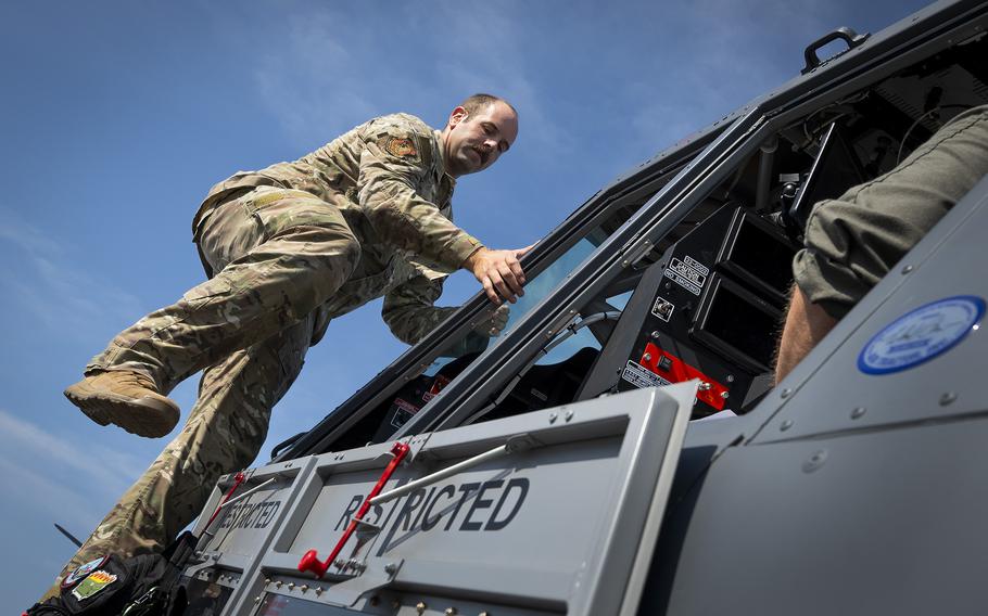 An airman climbs into an aircraft.