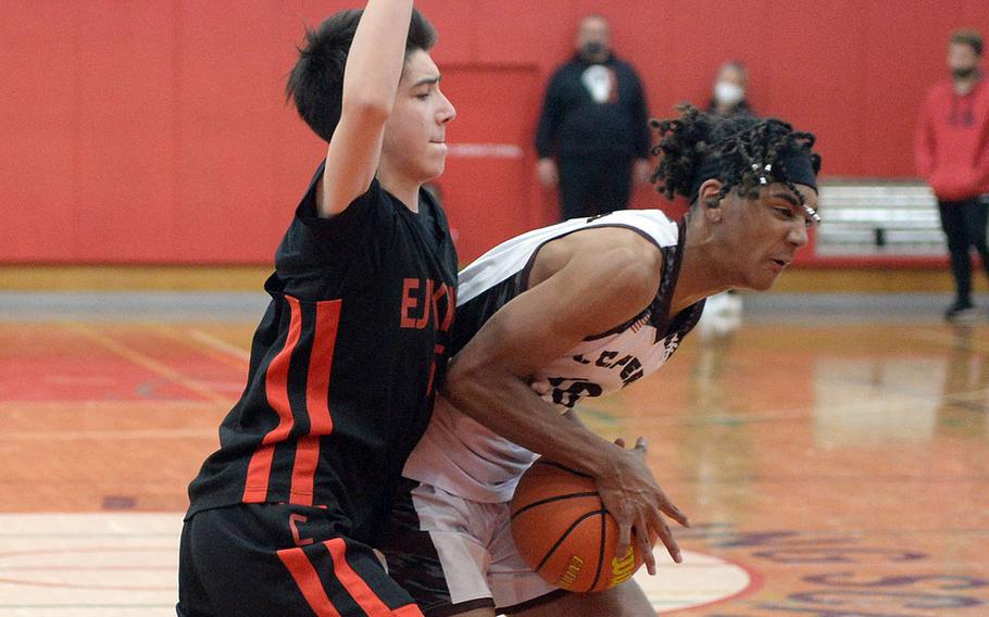 Matthew C. Perry's Shion Fleming shields the ball from E.J. King's Cameron Reinhart during Saturday's DODEA-Japan basketball game. The Cobras rallied from a 12-point third-quarter deficit to win 72-59.