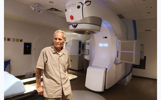 Louis Gomez, 94, of Delray Beach, near an x-ray radiation machine at the South Florida Proton Therapy Institute in Delray Beach on Tuesday, May 23, 2023. Gomez a cancer survivor and veteran believes he got cancer because of radiation exposure and beat it because of radiation therapy. (Carline Jean/South Florida Sun Sentinel)