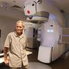 Louis Gomez, 94, of Delray Beach, near an x-ray radiation machine at the South Florida Proton Therapy Institute in Delray Beach on Tuesday, May 23, 2023. Gomez a cancer survivor and veteran believes he got cancer because of radiation exposure and beat it because of radiation therapy. (Carline Jean/South Florida Sun Sentinel)