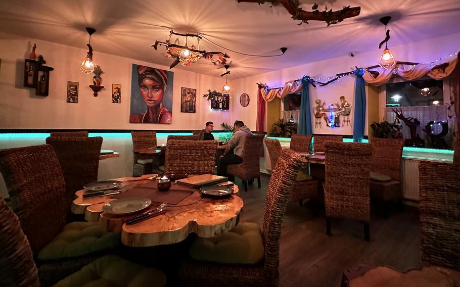 The inside of Casa do Brasil steakhouse in Vilseck, Germany, is furnished with edgewood tables, various artwork and candlelight. 
