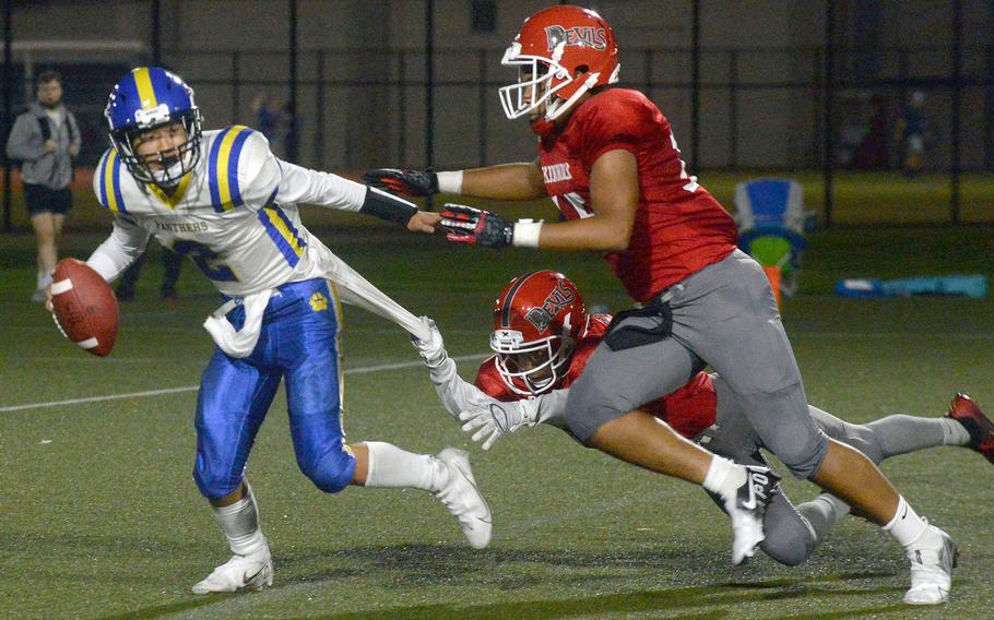 Nile C. Kinnick defenders Michael Lozano and Keith Reed chase down Yokota quarterback Dylan Tomas.