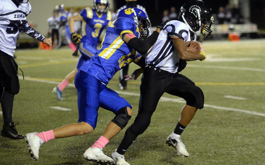 Zama back Alec Carter tries to shed the tackle of Yokota's Braedan Raybon.