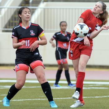 Nile C. Kinnick's Bree Withers fields the ball against E.J. King's Maliwan Schinker during Friday's DODEA-Japan soccer match. The teams battled to a 1-1 draw.