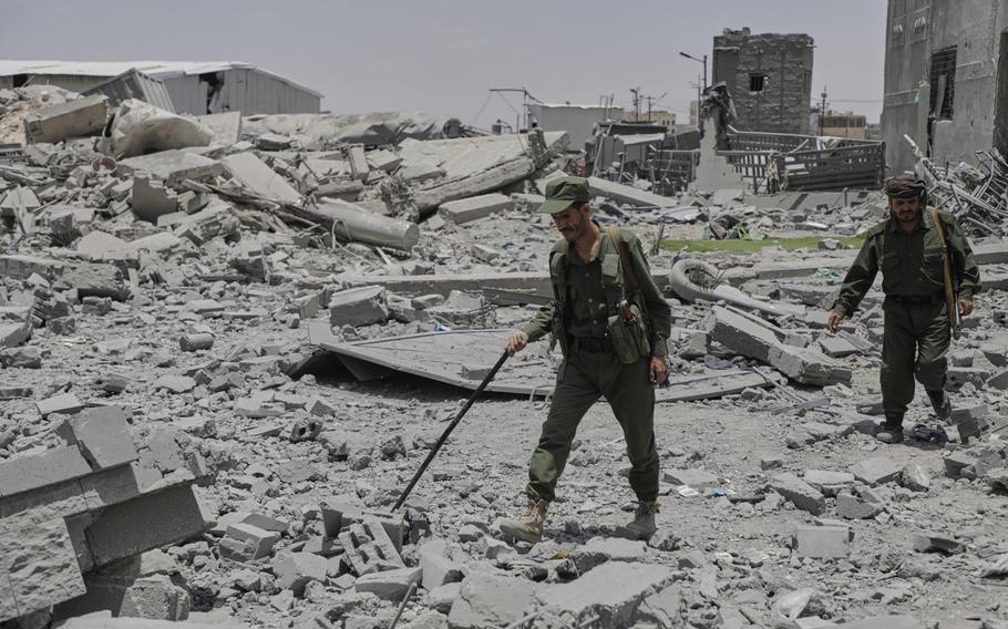 Yemeni soldiers inspect the damage reportedly caused by U.S. airstrikes
