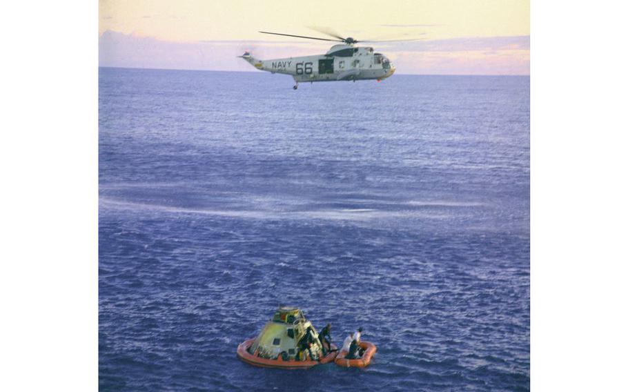 A U.S. Navy Sea King helicopter arrives to recover the Apollo 10 astronauts, seen entering a life raft, as the Command Module “Charlie Brown” floats in the South Pacific. 