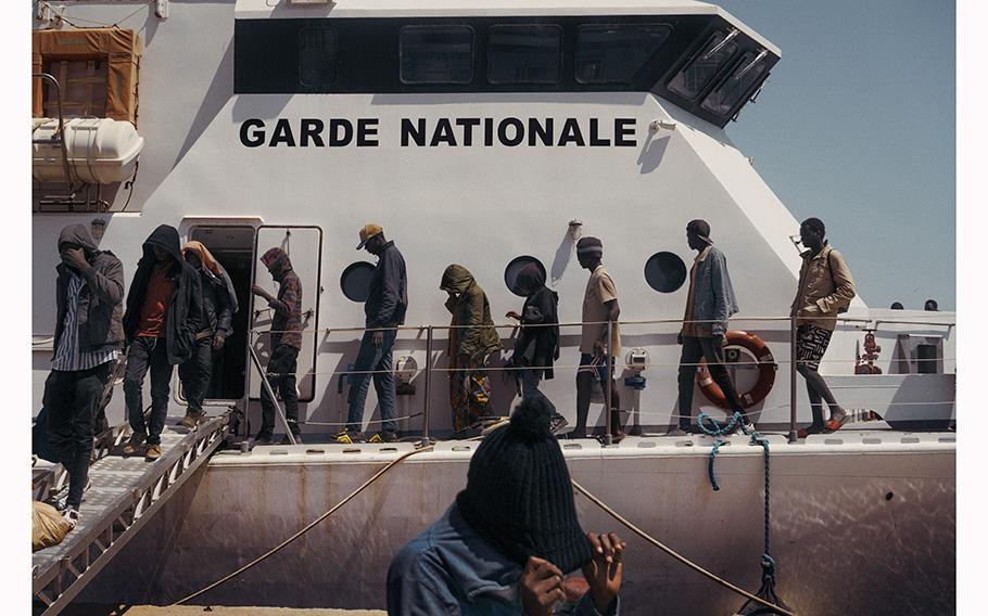 Migrants disembark from a Tunisian coast guard vessel in Sfax, Tunisia, on May 27, 2023, after their boat was intercepted at sea. 