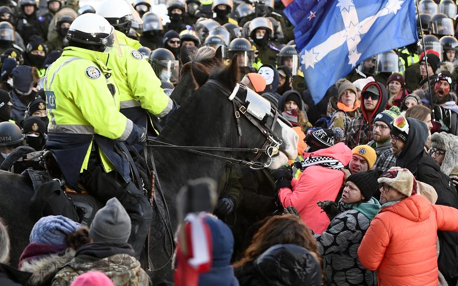 Protesters react as Toronto Police mounted unit move in to disperse them as police take action to put an end to a protest, which started in opposition to mandatory COVID-19 vaccine mandates and grew into a broader anti-government demonstration and occupation, Friday, Feb. 18, 2022, in Ottawa.
