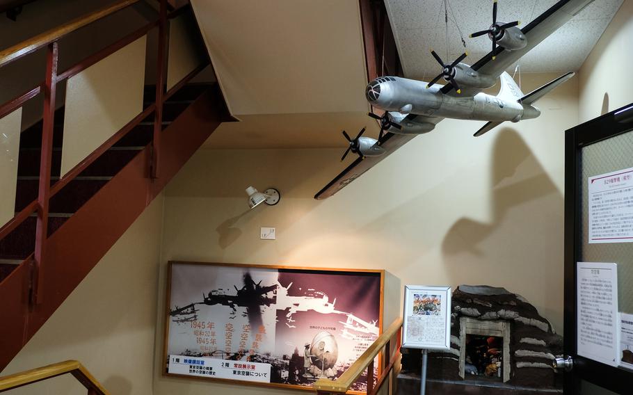 A model of a U.S. B-29 Superfortress bomber hangs over a  model of a Japanese civilian bomb shelter at the Center of the Tokyo Raids and War Damage in Tokyo, April 22, 2025.