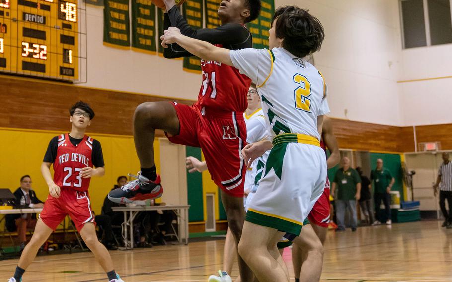 Nile C. Kinnick's Brandon Doctor skies for a shot against Robert D. Edgren's Caleb Kennedy during Friday's DODEA-Japan boys basketball game. The Red Devils won 65-31.