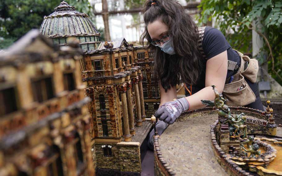 Annie Gessendorf works on the electricity for the newest creation in the Holiday Train Show, a miniature of the LuEsther T. Mertz Library, at the New York Botanical Garden in New York, Thursday, Nov. 11, 2021. The show, which opens to the public next weekend, features model trains running through and around New York landmarks, recreated in miniature with natural materials. 