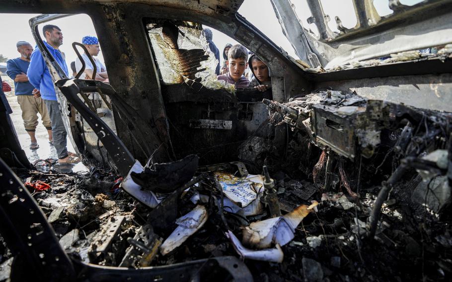 People inspect the site where World Central Kitchen workers were killed in Deir al-Balah, Gaza Strip, on April 2, 2024.