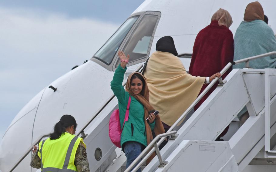 A woman waves before boarding a commercial flight taking evacuees from Afghanistan to the United States. The Boeing 767 departed Ramstein Air Base, Germany, on Aug. 26, 2021, for Dulles International Airport near Washington, D.C.