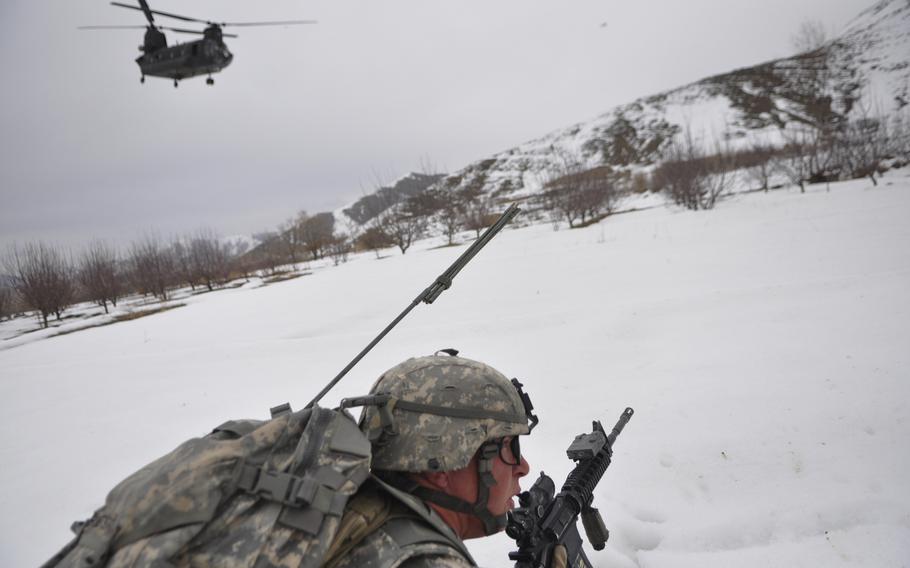 Spc. David Robertson, 42, of Petaluma, Calif., lies in the snow after being dropped off by a Chinook helicopter for a mission in Wardak province. Robertson and his fellow soldiers with Company B, 173rd Airborne Brigade Combat Team are reaching out to villagers ahead of the traditional summer fighting season.