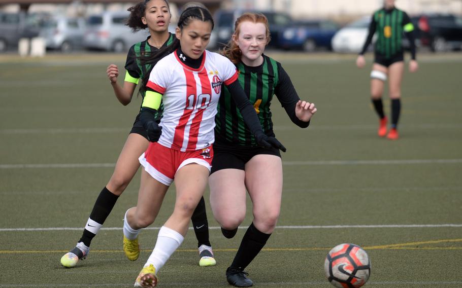 Nile C. Kinnick's Mikaila Joi Miranda outruns Robert D. Edgren's Kyla Smith and A'mya Ross for the ball during Saturday's DODEA-Japan girls soccer match. Miranda scored four goals, giving her seven in two games, as the Red Devils shut out the Eagles 5-0.