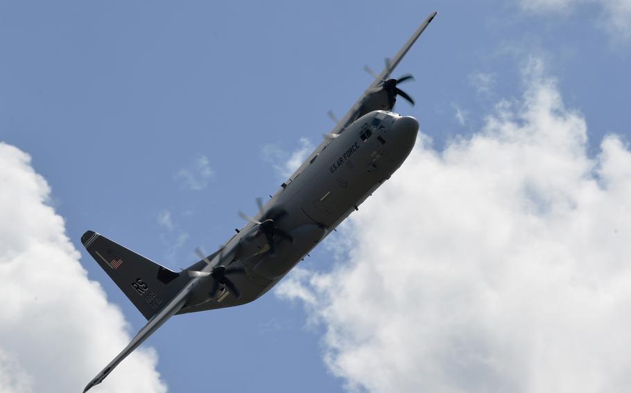 A C-130J Super Hercules of the 37th Airlift Squadron banks into a turn over Ramstein Air Base, Germany, flying in formation with eight other C-130s in an exercise that saw the rarity of paratroopers dropping in to the busy base.