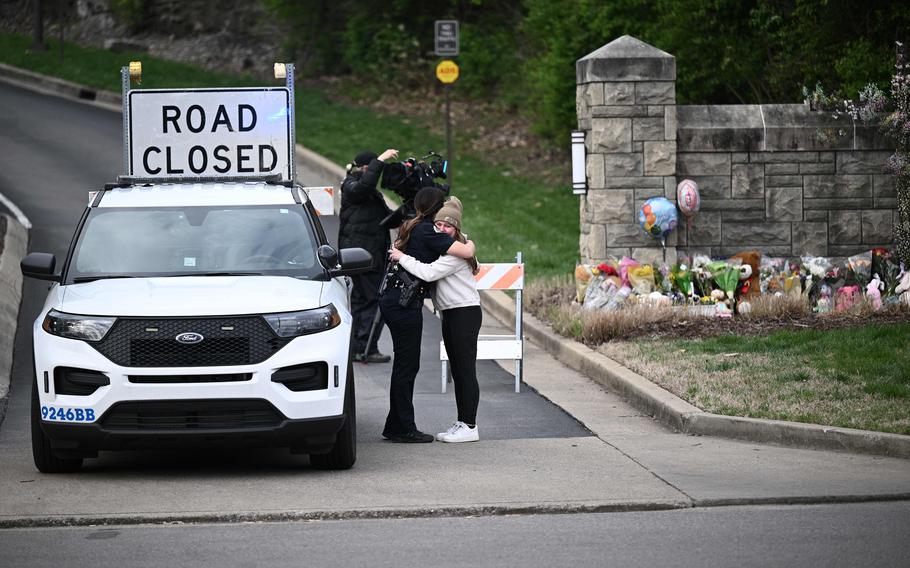 A woman hugs a police officer at the entrance of the Covenant School at the Covenant Presbyterian Church, in Nashville, Tenn., March 28, 2023. A heavily armed former student killed three young children and three staff in what appeared to be a carefully planned attack at a private elementary school in Nashville before being shot dead by police.