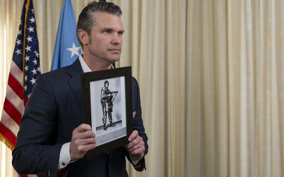 Pete Hegseth holds a photograph as he talks about a recently identified Korean War soldier 