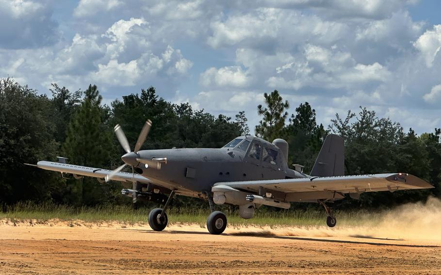 An aircraft lands on a dirt path.