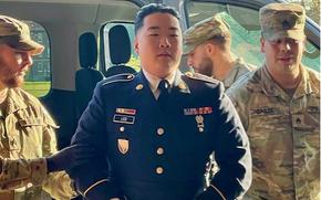 Two soldiers flank Lee, who is in uniform.