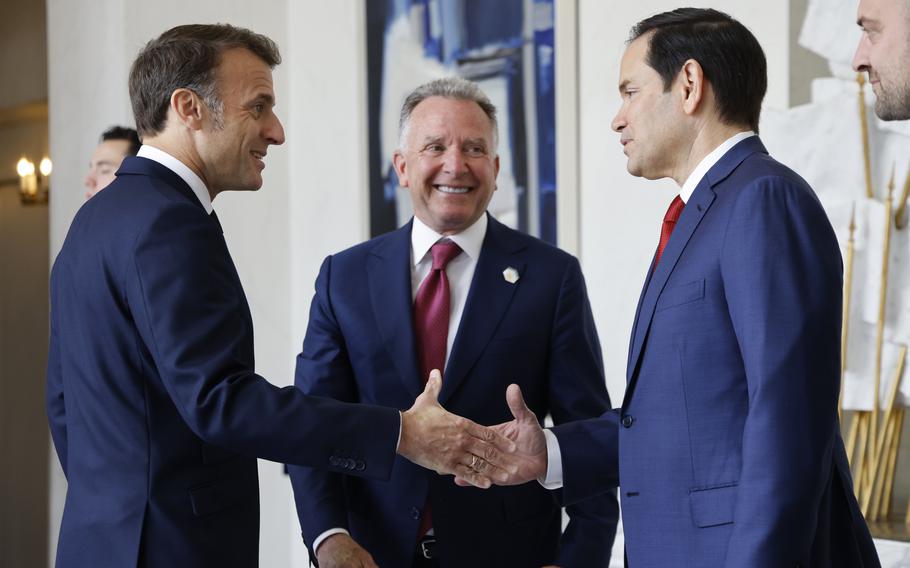 Emmanuel Macron shakes hands with Marco Rubio as Steve Witkoff stands behind them.