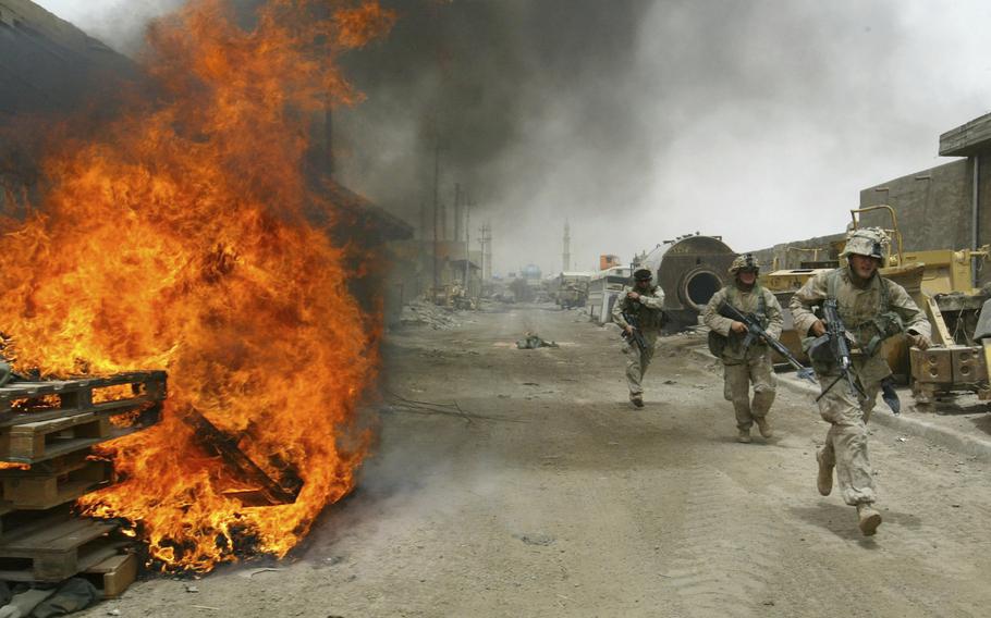 In this April 30, 2004, file photo, U.S. Marines burn their fortifications on front line positions in Fallujah, Iraq, before pulling out of the city.