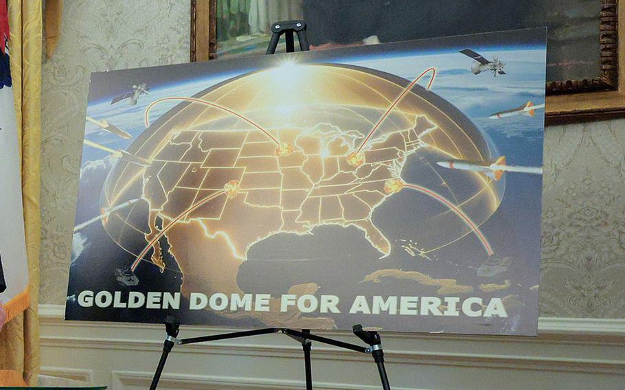 A poster resting on an easel reads “Golden Dome for America” with an artist’s rendering of a gold-colored defense dome over a map of the United States.