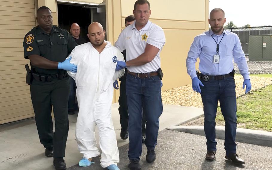 Quadruple murder suspect Bryan Riley is led from the Polk County Sheriff’s Office in Lakeland, Fla., on Sunday, Sept. 5, 2021, by Deputy Steve Neil, left, Captain Bart Davis and Detective Brett Bulman.