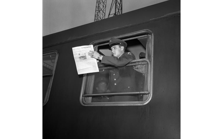 Pvt. Elvis Presley holds a Stars and Stripes newspaper as he looks from a troop train window on his departure from Bremerhaven, Germany, to duty at Friedberg, near Frankfurt.