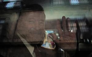U.S. Ambassador to Mexico Ronald Johnson waves from the inside of a vehicle while leaving the National Palace.