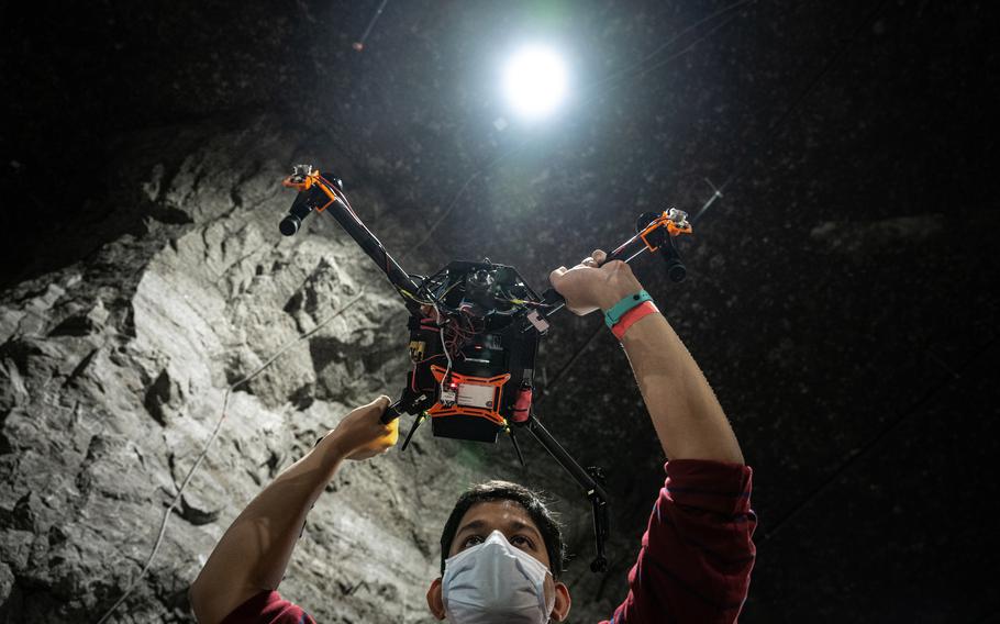 A member of one of the robotics teams holds a drone.