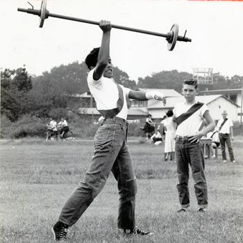 George Silver lifts the weights high above his head in the Junior Olympics, part of the Narimasu Elementary School, Grant Heights’ physical fitness program. Events included wrestling, volleyball, sumo, softball throwing and dashes. Silver would go on to win the weightlifting competition. 