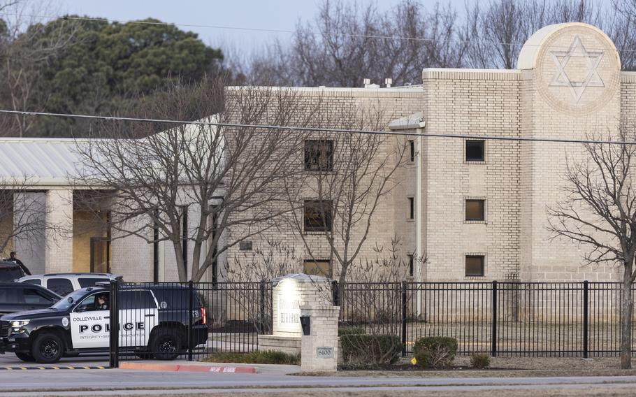 Police stand in front of the Congregation Beth Israel synagogue, Sunday, Jan. 16, 2022, in Colleyville, Texas. A man held hostages for more than 10 hours Saturday inside the temple. The hostages were able to escape and the hostage taker was killed. FBI Special Agent in Charge Matt DeSarno said a team would investigate "the shooting incident." 