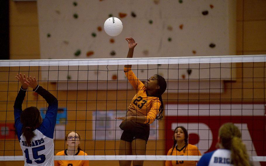 Spangdahlem's Laila Leggett hits the ball while Brussels' Sonia Desir jumps up at the net to block during pool-play action of the DODEA European volleyball championships on Oct. 26, 2023, at Kaiserslautern High School in Kaiserslautern, Germany.