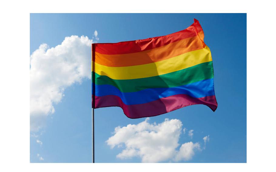 A Pride flag flaps in the wind.