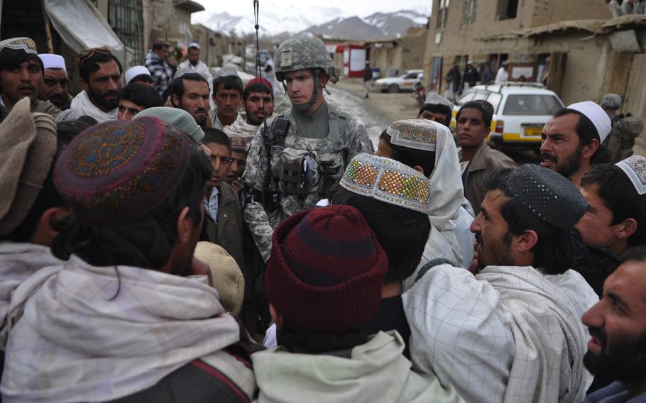 Villagers surround 1st Lt. Dennis Porter, 25, of McLean, Va., in the town of Khanjankhel, in Wardak province. Many villagers complained that when U.S. soldiers come to town with helicopters buzzing overhead, it scares women and children.