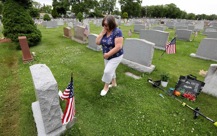 Barbara Rhoads prays at the grave of her son Spc. Ryan Rhoads who died while serving his country, at the Holy Redeemer Cemetery, in South Plainfield, N.J., May, 23, 2022