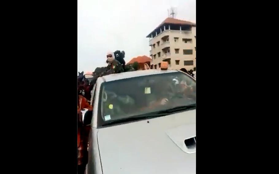 In a screenshot from a video posted on Twitter, a car carrying U.S. soldiers passes through a raucous crowd in the African country of Guinea. A coup there forced U.S. Africa Command to cancel a training event.