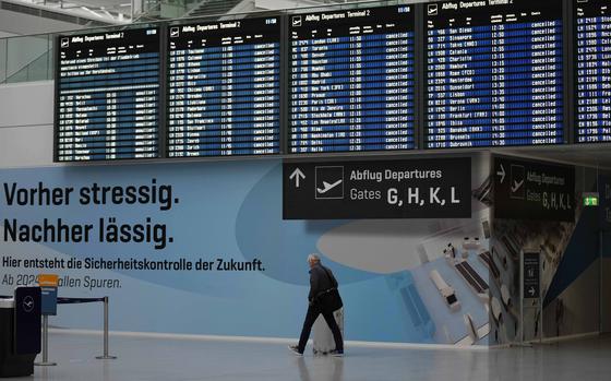 A man passes the deserted departure terminal during a strike in Bavaria at the airport in Munich, Germany, Sunday, March 26, 2023.