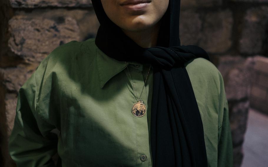 A young woman in the Old City of Nablus wears a necklace featuring images of dead militants.