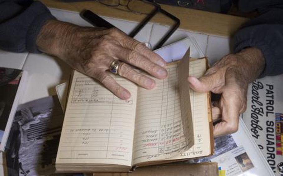 Dick Higgins, who at 100 is the oldest living Pearl Harbor survivor in Central Oregon, looks through his flight logs at his desk on Oct. 7, 2021. Higgins served as a Navy radio operator in a PBY Catalina amphibious aircraft when Japan attacked Pearl Harbor on Dec. 7, 1941.