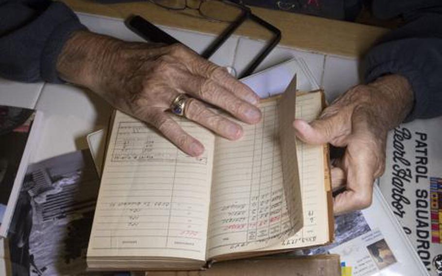 Dick Higgins, who at 100 is the oldest living Pearl Harbor survivor in Central Oregon, looks through his flight logs at his desk on Oct. 7, 2021. Higgins served as a Navy radio operator in a PBY Catalina amphibious aircraft when Japan attacked Pearl Harbor on Dec. 7, 1941.