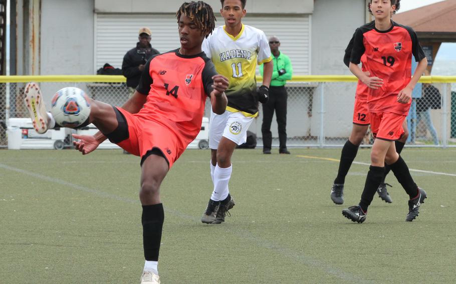 Nile C. Kinnick's Myhki Russell steadies the ball in front of Kadena's Yoshua Whipp and teammate Luis Galloway during Monday's Division I boys soccer match. The Panthers won 2-0.