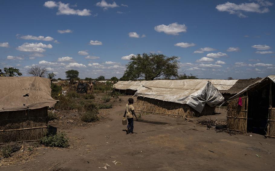 A refugee boy walks through tents in a village near Pemba, Mozambique, on Sept. 2, 2022.