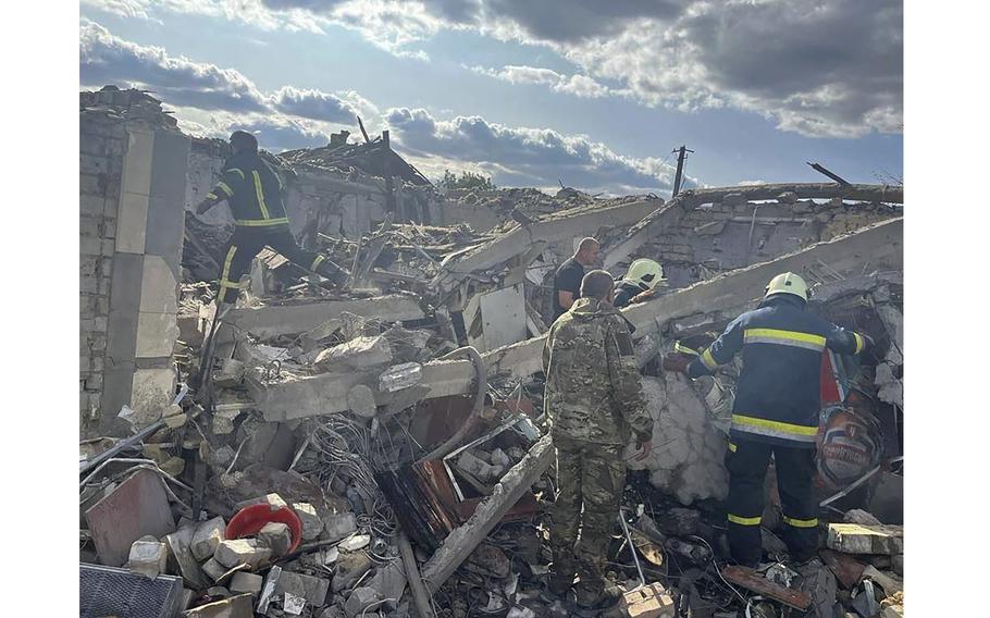 Emergency workers search the victims of a Russian rocket attack that killed at least 47 people in the village of Hroza near Kharkiv, Ukraine, Oct. 5, 2023.