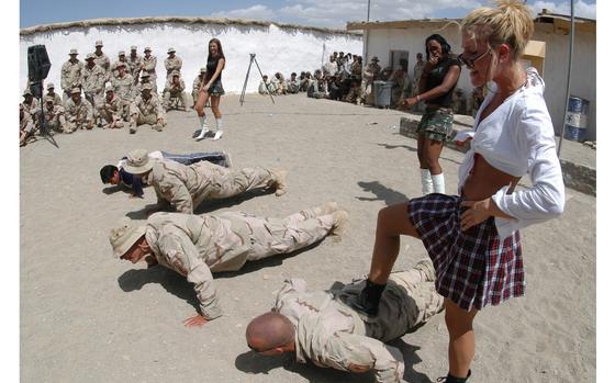 Forward Operating Base Sweeney, Afghanistan, July 4, 2005: Soldiers do pushups under the watchful eye - and foot - of Denver Bronco cheerleader Holly Baack during a 4th of July show at FOB Sweeney in southeastern Afghanistan before playing the song "Hot for Teacher" by Van Halen.  The cheerleaders performed two shows for 173rd Airborne troops on Independence Day, one at Sweeney and another at Camp Lagman.

Read the story about the cheerleaders' visit here https://www.stripes.com/news/denver-broncos-cheerleaders-visit-bases-in-afghanistan-1.35475

MATE TAGS: Operation Enduring Freedom; USO show; football; enternainment; 
