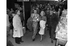 Frankfurt, Germany, June 19, 1948: Lana Turner and her new husband, tin-plate heir Henry (Bob) Topping, are being assisted by an American military official at the Frankfurt train station. The couple started their tour of the EC after two days of an off-again, on-again routine that kept reporters, photographers and fans running from Rhein-Main Airport to Frankfurt's railroad station and back. Turner was scheduled to spend 10 days enteraining U.S. troops througout the zone and Berlin, but she confessed she didn't know how. "Heaven only knows — just get out and say hello, I guess," she answered when asked what her act would be.